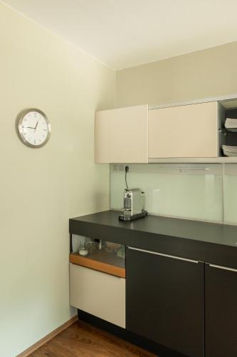 a kitchen with a counter and a clock on the wall at 240qm Luxus Apartment - Natur & Wandern zw Bozen und Meran in Nalles