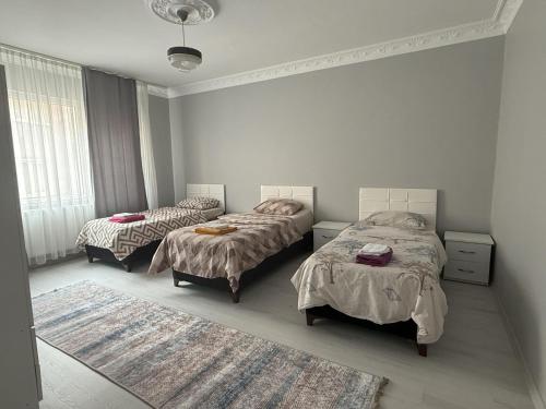 a bedroom with two beds and a rug at Only For Families Apartment in Istanbul