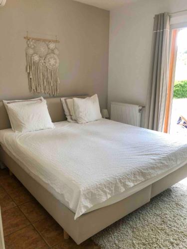 un lit avec des draps blancs et des oreillers dans une chambre dans l'établissement Superbe villa 10 personnes avec piscine, au Plan-de-la-Tour