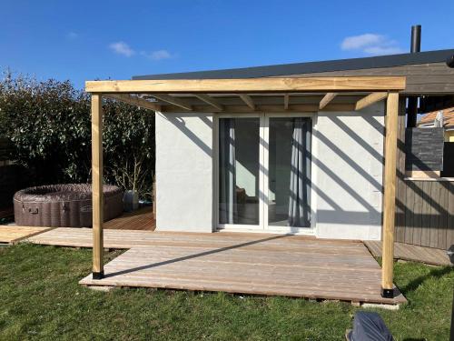 a wooden pergola on a deck in a yard at Location Spay Proche circuit in Spay