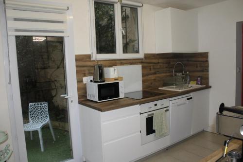 une cuisine avec un micro-ondes et un évier dans l'établissement Appartement climatisé dans un quartier très calme, à Six-Fours-les-Plages