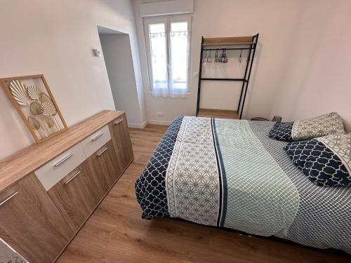 une chambre avec un lit avec une commode et un miroir dans l'établissement T2 de Charme Rénové à Beg-Meil, À 250m de la Plage, à Fouesnant