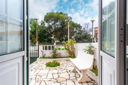 an open door to a patio with a white chair at HAUS NUNES by Stay in Alentejo in Vila Nova de Milfontes