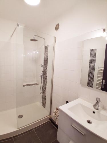 une salle de bain blanche avec une douche et un lavabo dans l'établissement Studio ST CYR SUR MER, aux Lecques