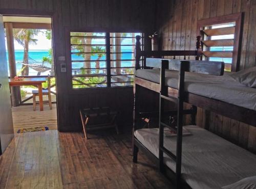 a room with bunk beds and a view of the ocean at Ratu Kini Dive & Stay in Mana Island