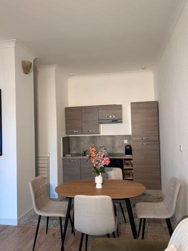 une pièce avec une table et des chaises et une cuisine dans l'établissement Appartement chaleureux en centre ville, à Nîmes