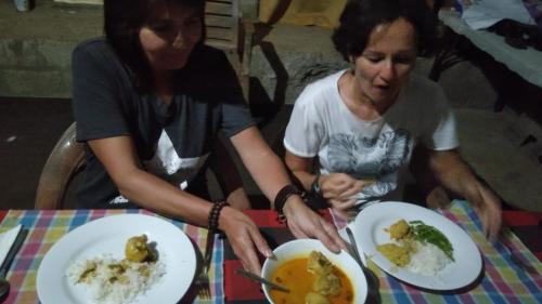 two women sitting at a table with plates of food at A9 home residence in Tangalle