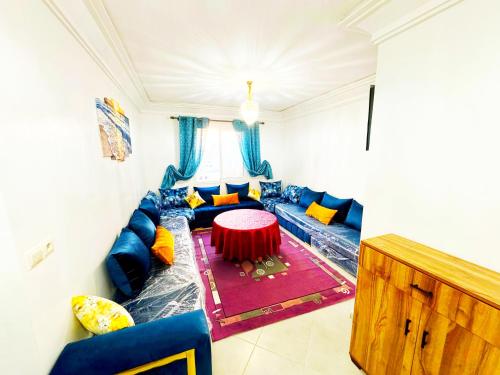 a living room with a blue couch and a red table at Luxury Seafront Apartment in Agadir Vue Mer Taghazout Surf & Ocean View your Home place in Agadir