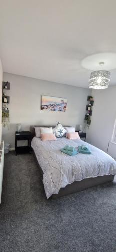 a bedroom with a large bed with pink pillows at Unique Exmouth Family Holiday Home Close to Beach & Town in Exmouth