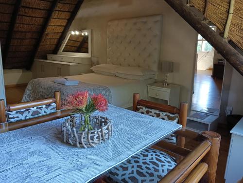 a room with a table with a bed and a table with chairs at Little Tree Loft in Uitenhage