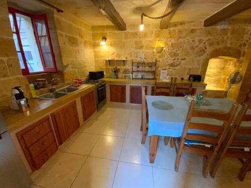QalaにあるTa Randu Farmhouse with Stunning Poolのキッチン(テーブル、椅子、シンク付)