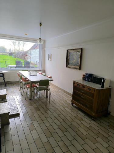 a dining room with a table and chairs and a window at Hoge Weg in Oudenaarde