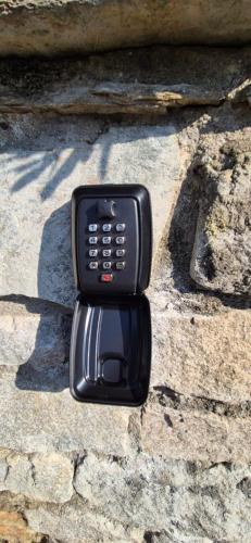 a black cell phone sitting on a stone wall at La Mansarda sul lago in Bellano