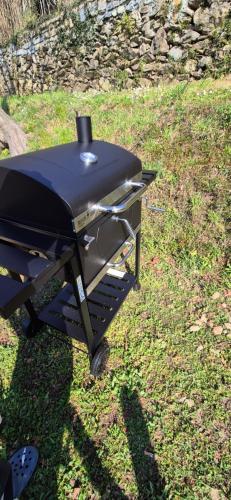a barbecue grill sitting on the grass in the yard at La Mansarda sul lago in Bellano