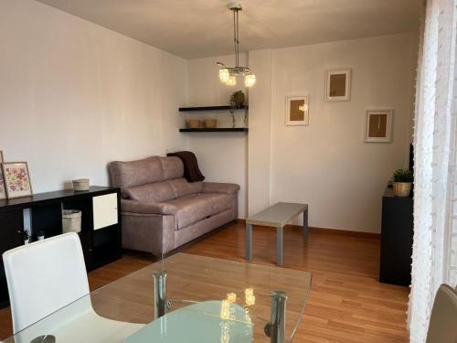 a living room with a couch and a glass table at Apartamento para turismo en Granada in Peligros
