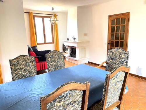 une salle à manger avec une table et des chaises bleues dans l'établissement Le Jardin d'Auguste, à Roussillon