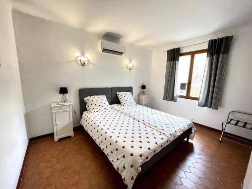 une chambre blanche avec un lit et une fenêtre dans l'établissement Le Jardin d'Auguste, à Roussillon