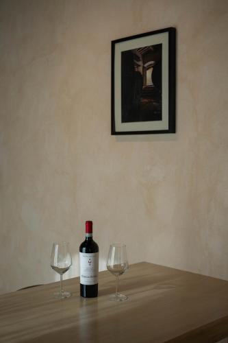 a bottle of wine and two wine glasses on a table at Tenuta San Jacopo - Agriturismo in Cavriglia