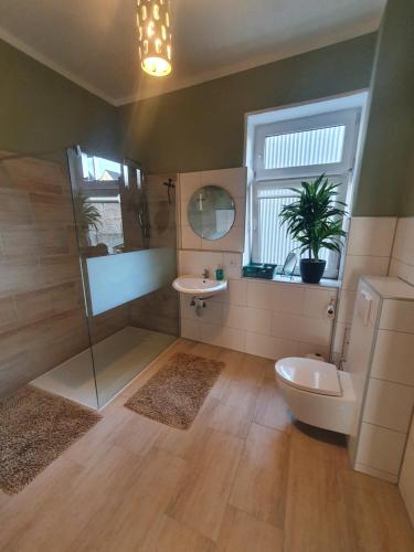 łazienka z prysznicem, toaletą i umywalką w obiekcie Große, familienfreundliche Ferienwohnung, ruhig im Zentrum von Güstrow w mieście Güstrow