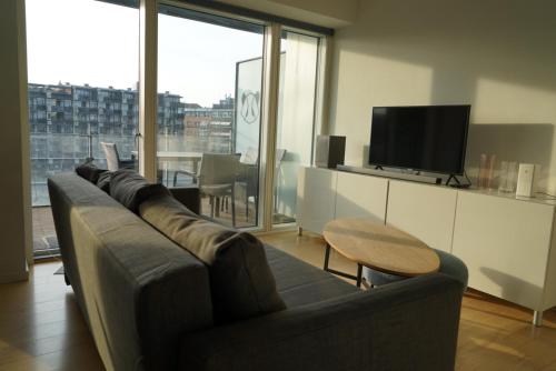 a living room with a couch and a television at Copenhagen City Luxe Retreat in Copenhagen
