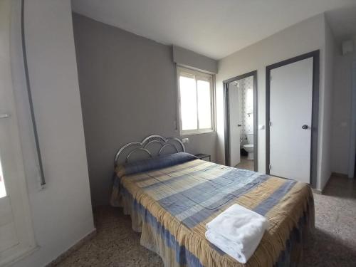 a bedroom with a bed with a blue and yellow blanket at Hostal San Miguel in Villalobar