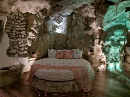 a bedroom with a bed in a rock wall at B&B La Casa nella Roccia in Villanova del Battista