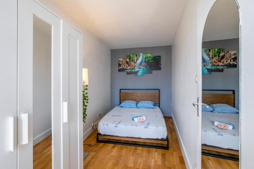 - une chambre avec 2 lits dotés d'oreillers bleus dans l'établissement Le Cocon - Climatisation, Balcon, Wifi, Beaux Arts, à Montpellier