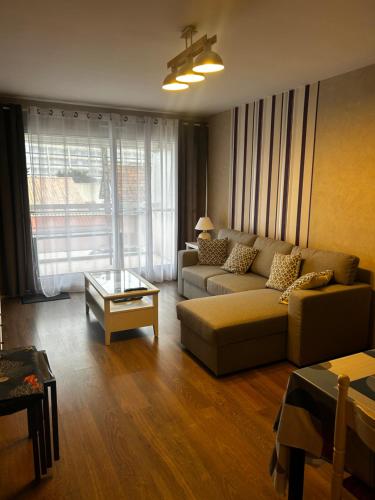 un salon avec un canapé et une table dans l'établissement Appartement La Maison d Ulysse, à Saint-Hilaire-de-Riez