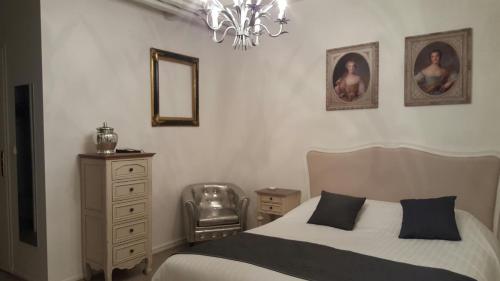 - une chambre avec un lit, une chaise et un miroir dans l'établissement Château de Salles, à Vezac