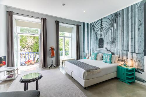 a bedroom with a large white bed and a couch at Emporium Lisbon Suites in Lisbon