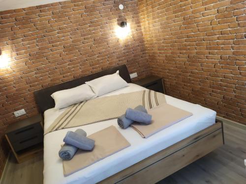 a bedroom with a bed with two pillows and a brick wall at Bakery apartments in Perea