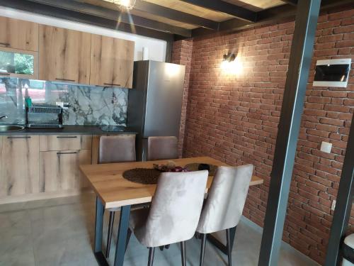 a kitchen with a wooden table and a brick wall at Bakery apartments in Perea