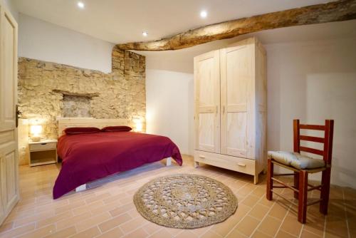 a bedroom with a red bed and a chair at Casa Anton - La Solana in Alsamora