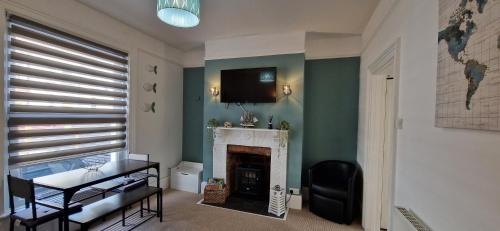 a living room with a fireplace and a tv on the wall at Unique Exmouth Family Holiday Home Close to Beach & Town in Exmouth