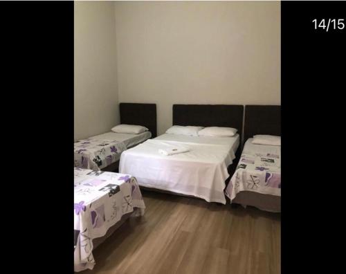 a room with two beds with white sheets on them at Hotel life Ijuí in Ijuí