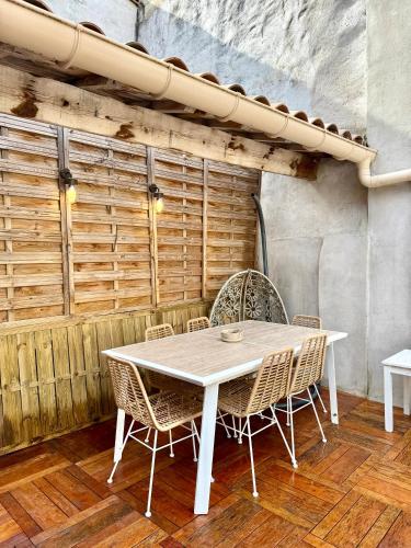 - une table et des chaises blanches dans la chambre dans l'établissement Superbe appartement grande terrasse centre ville St Rémy, à Saint-Rémy-de-Provence