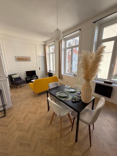 un salon avec une table et un canapé jaune dans l'établissement L'Instant Chic - Appartement à 5min à pied de Nausicaa, plage, centre Ville, à Boulogne-sur-Mer