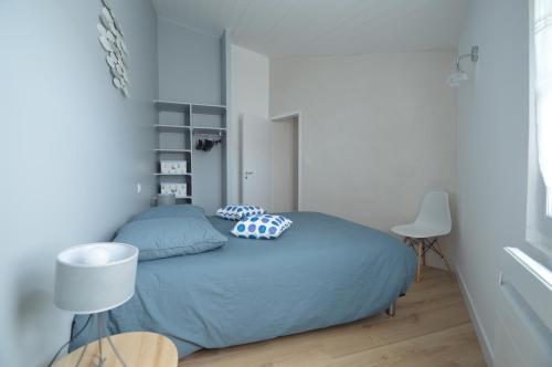 une chambre avec un lit avec des oreillers dessus dans l'établissement Chai RHETAIS, au Bois-Plage-en-Ré