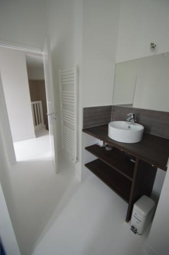 une salle de bain avec un lavabo et un miroir dans l'établissement Chai RHETAIS, au Bois-Plage-en-Ré