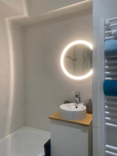 une salle de bain avec un lavabo et un miroir dans l'établissement Studio Blue Nimes - Centre Historique de Nimes, à Nîmes