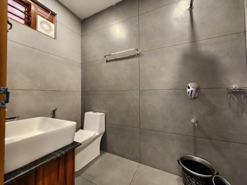 a bathroom with a sink and a toilet at Mana Gramam Resort Mudumalai in Mudumalai National Park