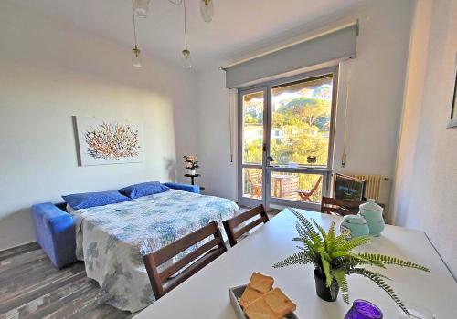 a bedroom with a bed and a table and a window at Cavi Sea View Apartment in Lavagna