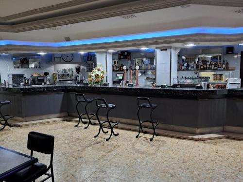 a bar with four chairs in front of it at Hostal San Miguel in Villalobar