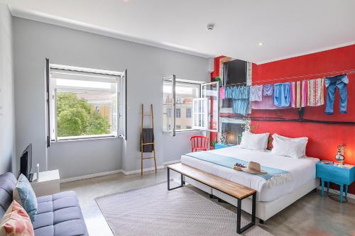a bedroom with a white bed and a red wall at Emporium Lisbon Suites in Lisbon