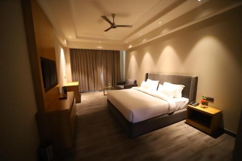 a hotel room with a bed and a ceiling fan at Hoatel Abha in Alīgarh