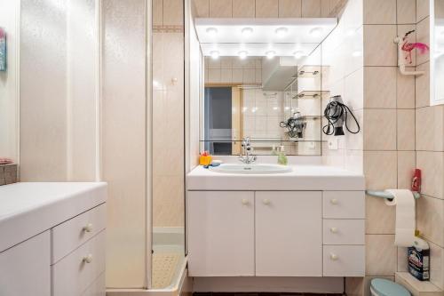 une salle de bain blanche avec un lavabo et un miroir dans l'établissement Studio 200m plage Terrasse WIFI fibre parking, aux Lecques