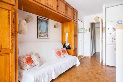 Cette chambre dispose d'un canapé blanc avec des oreillers. dans l'établissement Studio 200m plage Terrasse WIFI fibre parking, aux Lecques