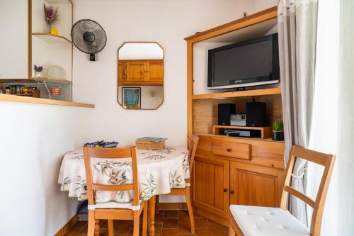 une petite salle à manger avec une table et une télévision dans l'établissement Studio 200m plage Terrasse WIFI fibre parking, aux Lecques