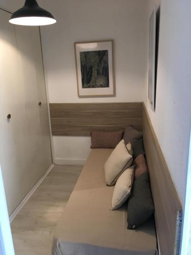 Cette petite chambre dispose d'un canapé et d'oreillers. dans l'établissement Les pieds dans l'eau, au Grau-du-Roi