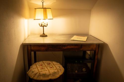 a table with a lamp on top of it at Hotel La Fonte Del Cerro in Saturnia